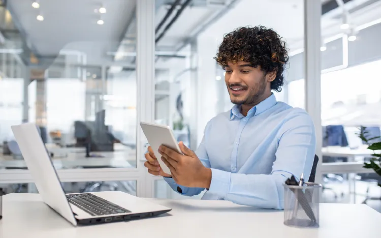 Business professional using tablet in modern office - introducing HCL Unica Plus martech platform