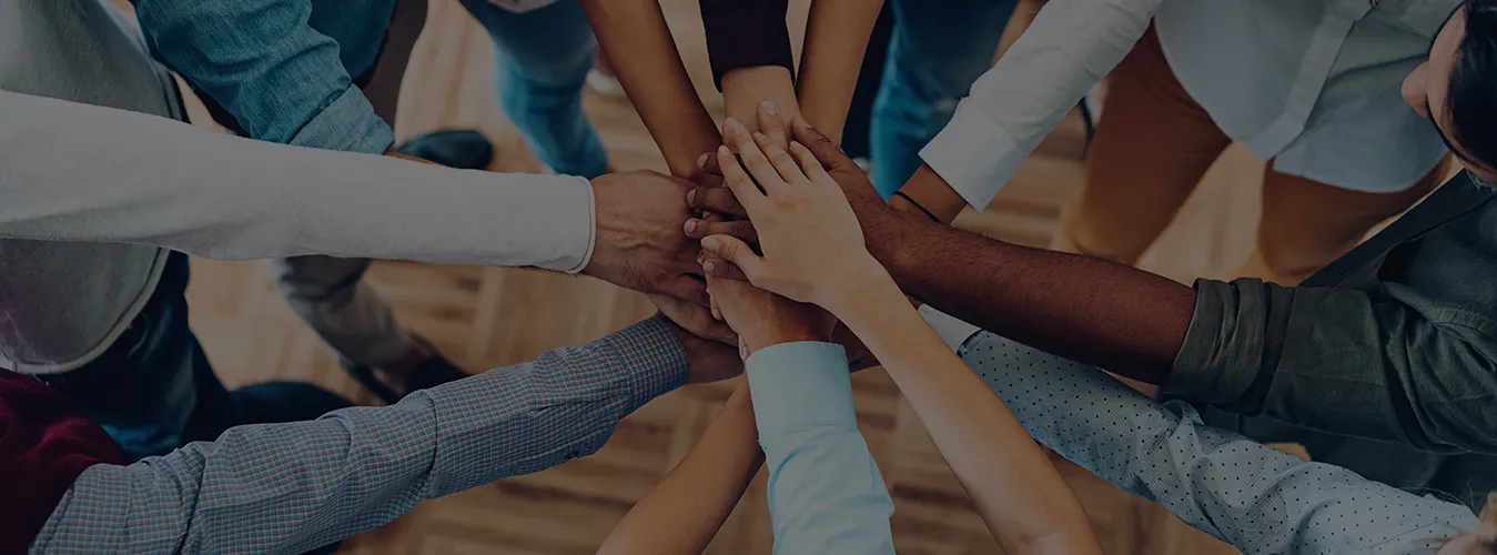 group of people uniting hands in a teamwork gesture