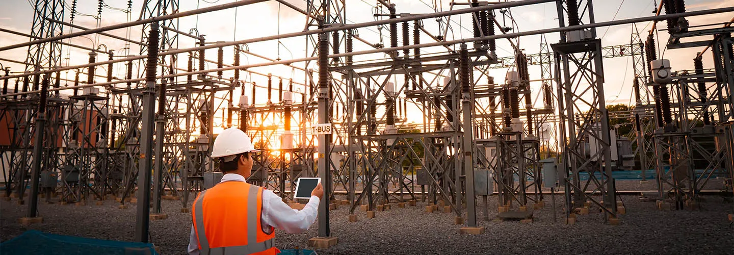 electrical power substation using a digital tablet at sunset